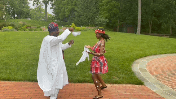 Couple dancing in traditional attire at an outdoor celebration